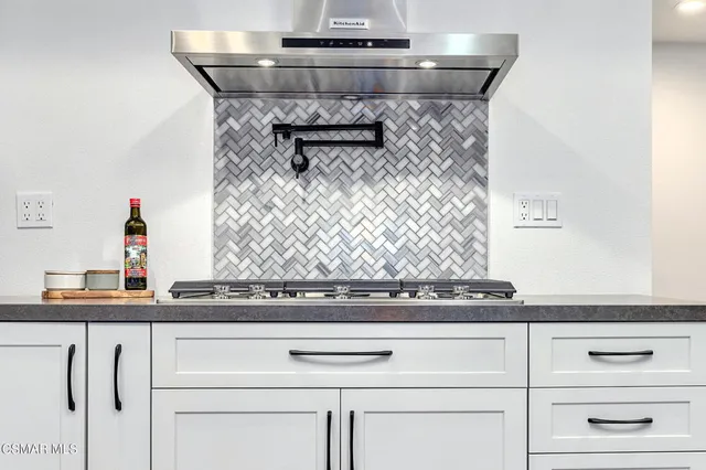 a kitchen with kitchen island granite countertop a sink a center island cabinets and wooden floor