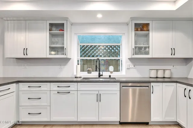 a spacious bedroom with a bed a dresser and a large window