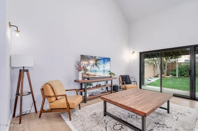 a living room with furniture a table and a large window