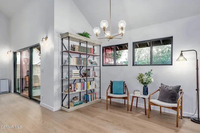 a view of a dining room with furniture a chandelier and a bookshelf