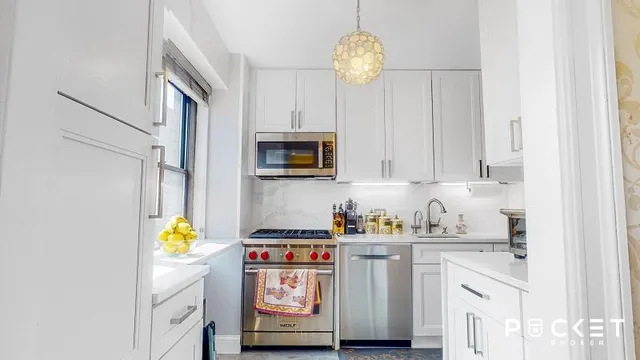 a kitchen with stainless steel appliances granite countertop a sink a stove cabinets and a refrigerator