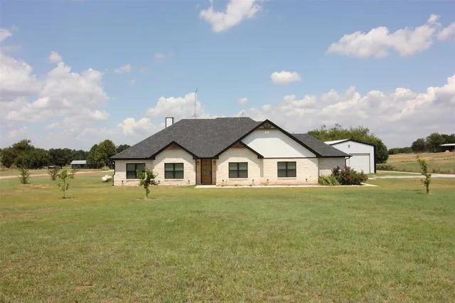 a view of a house with a yard and lake view