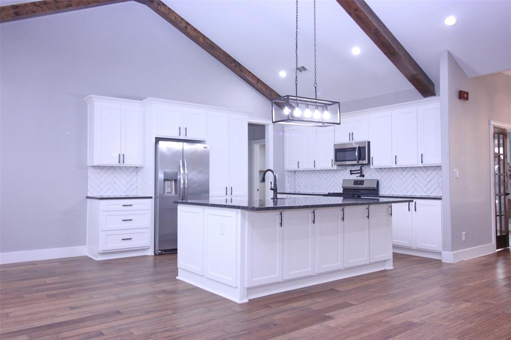 3238 Fm 2048 Boyd, TX 76023 - Photo 9 of 38 a large kitchen with cabinets wooden floor and stainless steel appliances