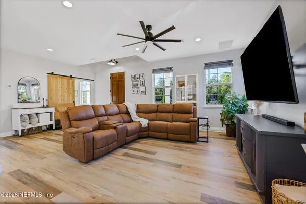 a kitchen with granite countertop a refrigerator a stove a dining table and chairs with wooden floor