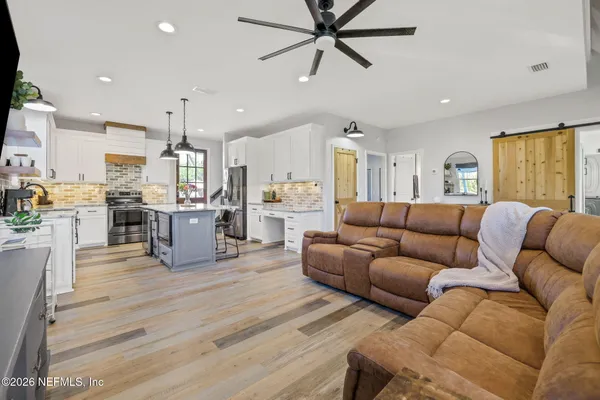a kitchen with granite countertop a sink a counter space appliances and cabinets