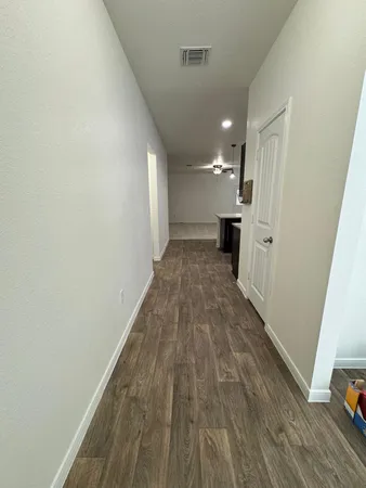 a view of a hallway with wooden floor and staircase
