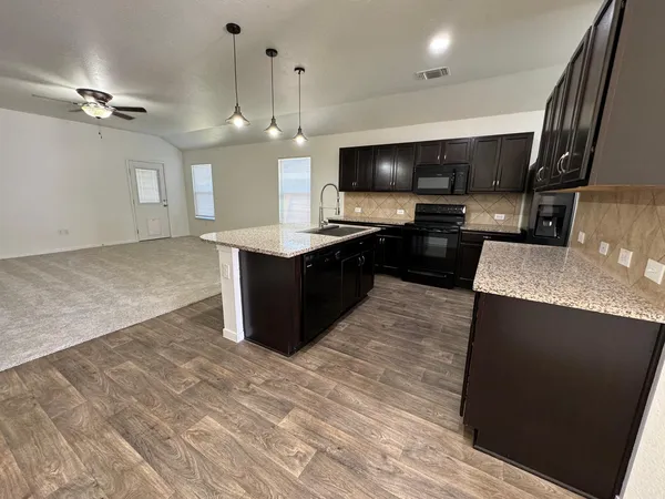 a kitchen with granite countertop a stove and a sink