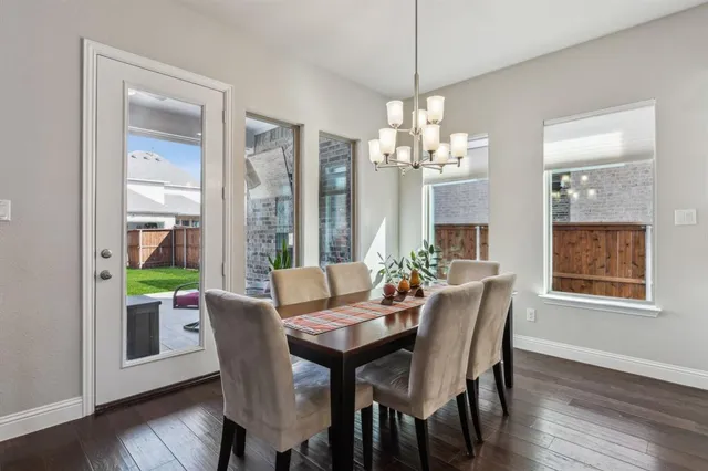 a view of a dining room with furniture a chandelier and wooden floor