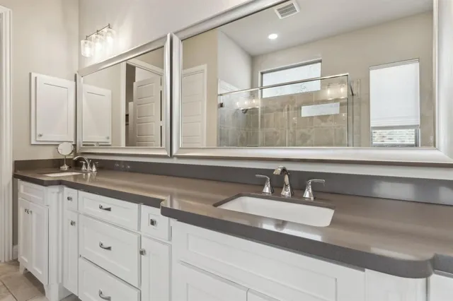 a bathroom with double sink and a mirror
