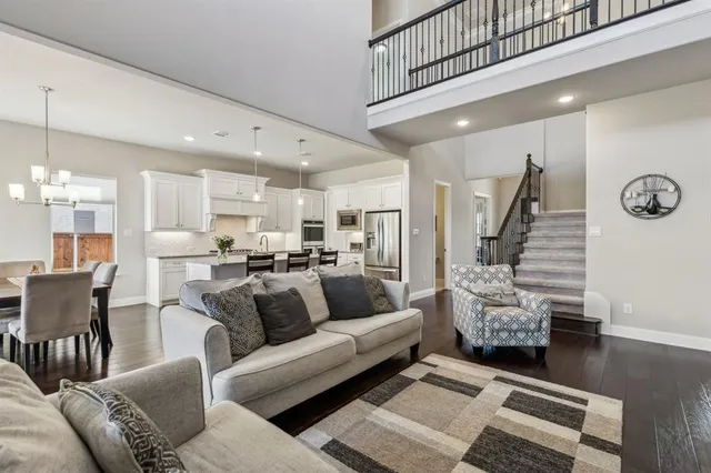 a living room with furniture kitchen view and a chandelier