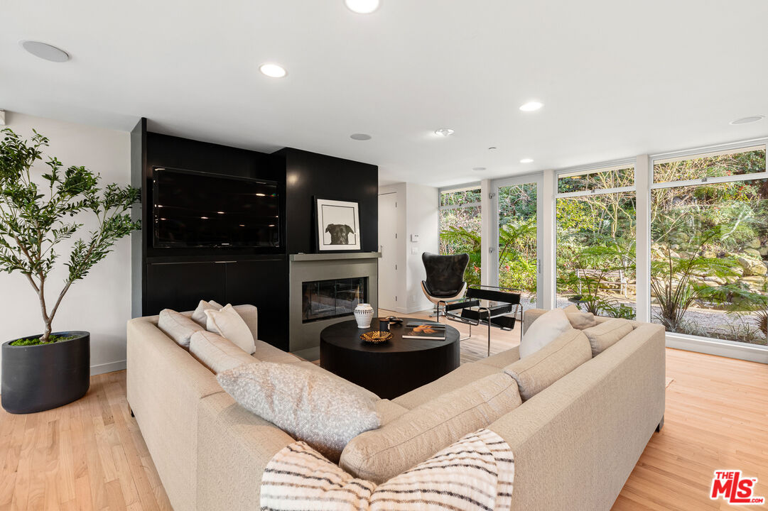 3114 Streamview Lane Studio City, CA 91604 - Photo 18 of 75 a living room with furniture a large window and a fireplace