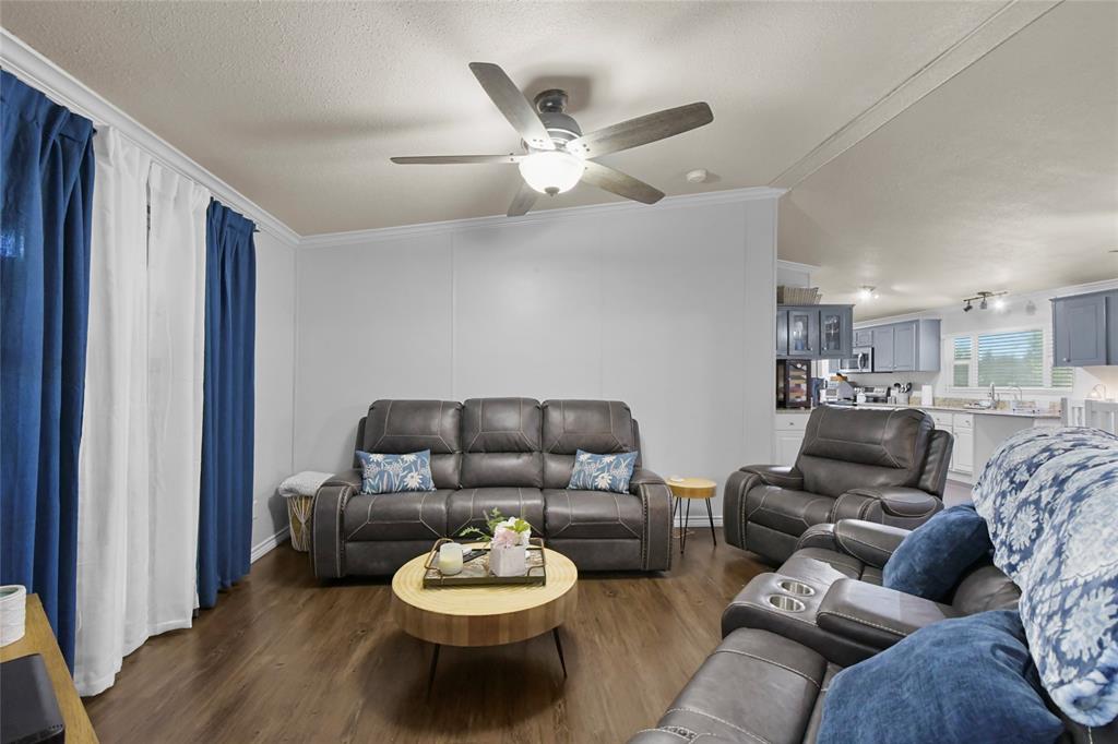 338 Fisherman Road Pottsboro, TX 75076 - Photo 4 of 24 Spacious living area featuring wood-finish flooring throughout, a ceiling fan with integrated lighting, and comfortable seating arrangements