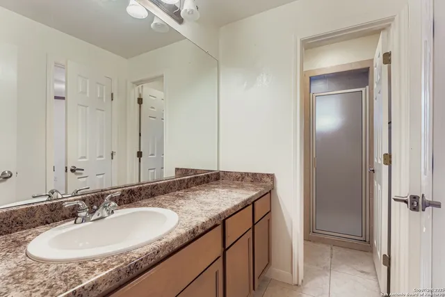 a bathroom with a granite countertop sink and a mirror