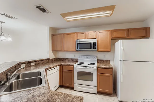a kitchen with a sink stove and white stainless steel appliances