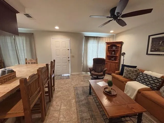 a living room with furniture a ceiling fan and a rug