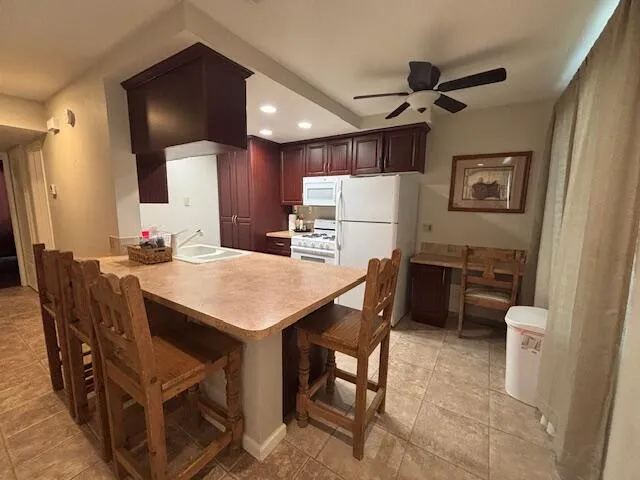 a kitchen with stainless steel appliances a table chairs and refrigerator