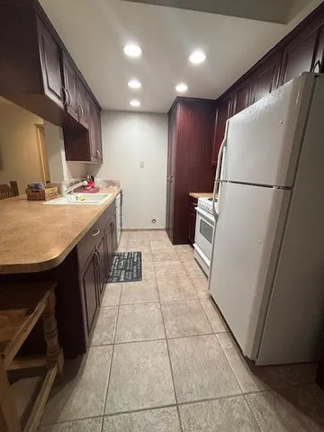 a white refrigerator freezer and a stove sitting inside of a kitchen