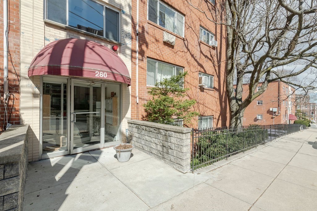280 Corey Road, Unit 23 Boston, MA 02135 - Photo 1 of 19 a view of a brick house with a large windows and a large tree
