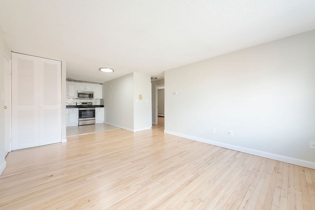 280 Corey Road, Unit 23 Boston, MA 02135 - Photo 4 of 19 a view of a kitchen with wooden floor and a refrigerator