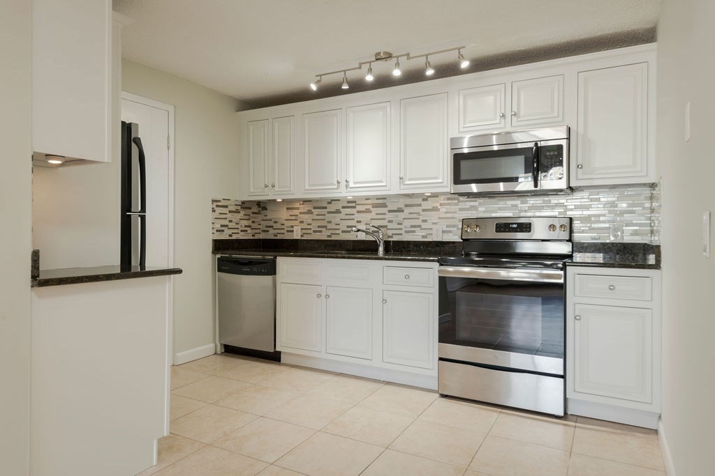280 Corey Road, Unit 23 Boston, MA 02135 - Photo 6 of 19 a kitchen with stainless steel appliances granite countertop a stove and a microwave