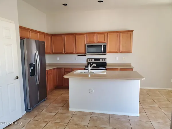 a kitchen with stainless steel appliances a refrigerator a stove a sink a microwave and cabinets