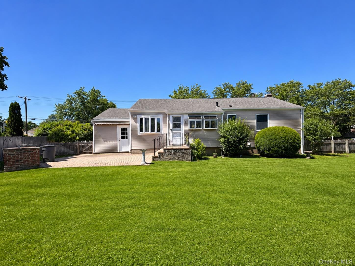 16 Clay Pitts Road Greenlawn, NY 11740 - Photo 20 of 25 Expansive green lawn with a single-story residence featuring light-colored siding