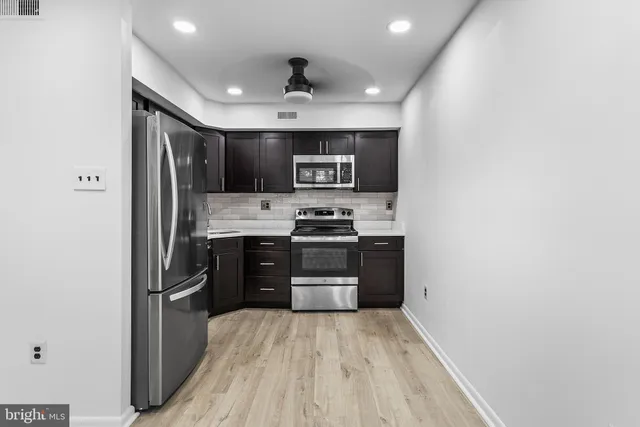 a kitchen with stainless steel appliances granite countertop a refrigerator and a stove