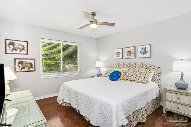 a bedroom with a large bed and a flat tv screen on dresser