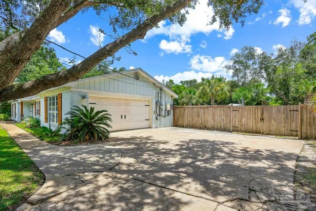 a front view of a house with a yard and potted plants
