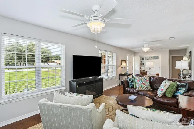 a living room with furniture a flat screen tv and a large window