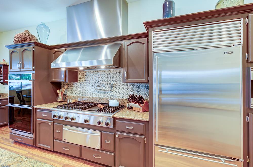17465 Monreal Road Madera, CA 93636 - Photo 25 of 59 a kitchen with a stove and a refrigerator