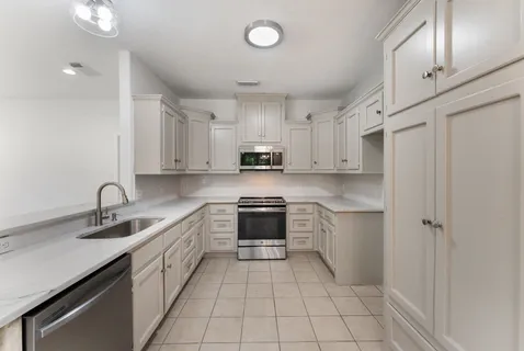 a kitchen with a sink appliances and cabinets