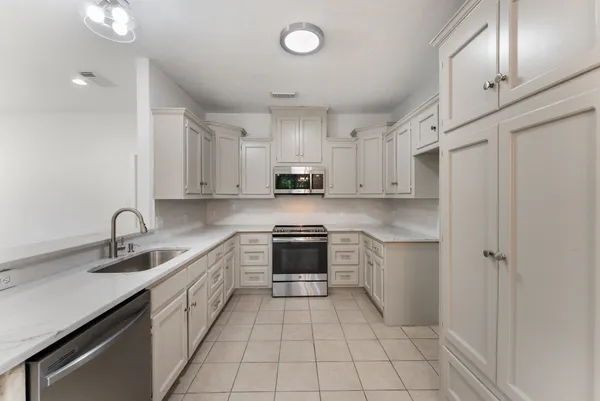 a kitchen with a sink appliances and cabinets