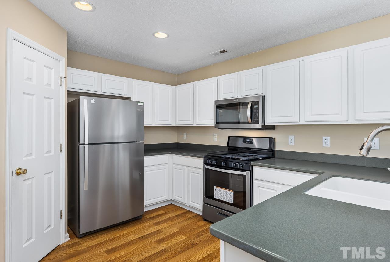 4808 Marathon Lane Raleigh, NC 27616 - Photo 8 of 31 a kitchen with a refrigerator a stove top oven a sink and dishwasher