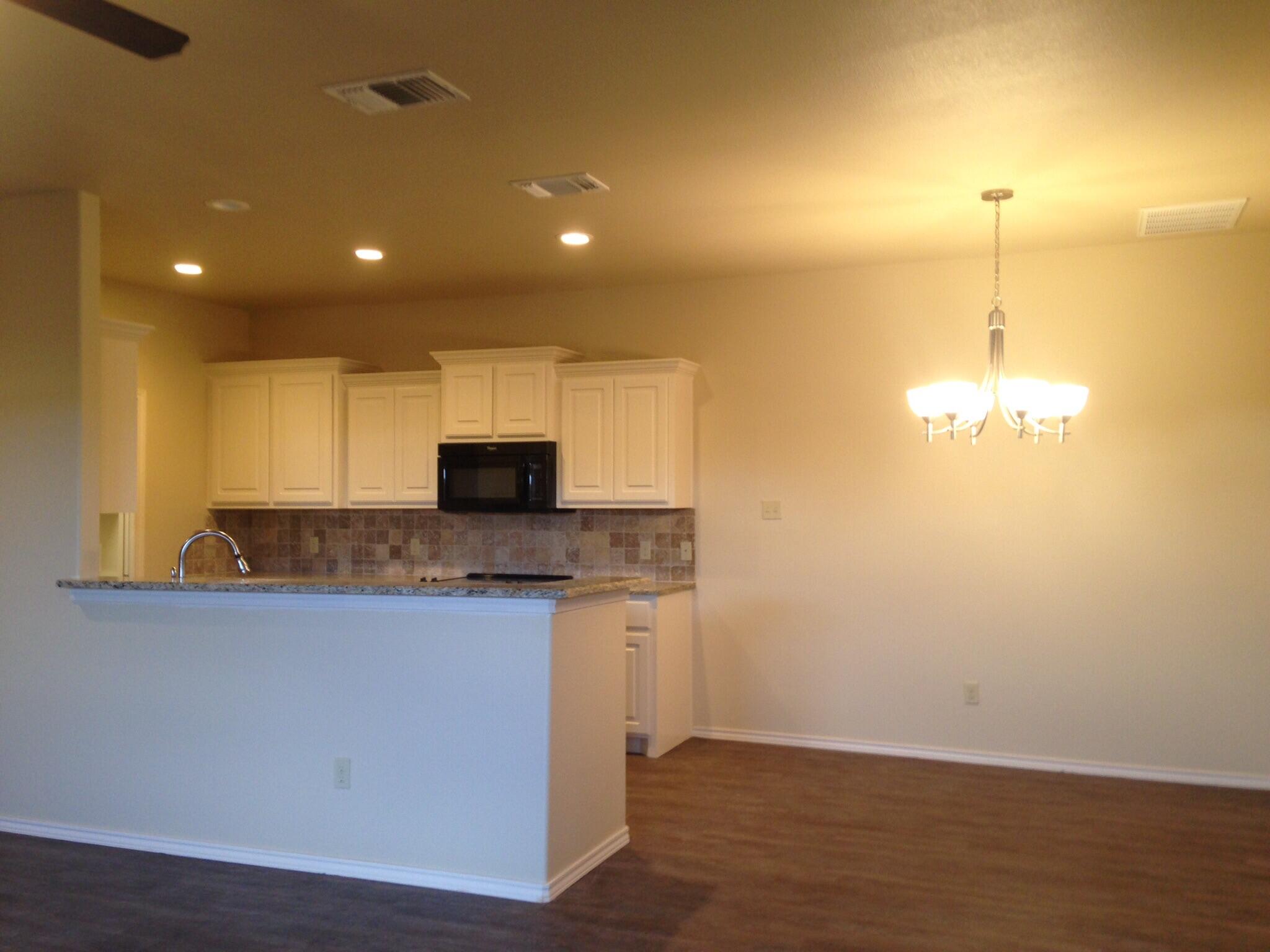 1212 Preston Trail, Unit A Wolfforth, TX 79382 - Photo 4 of 12 a view of a kitchen with a sink and a chandelier