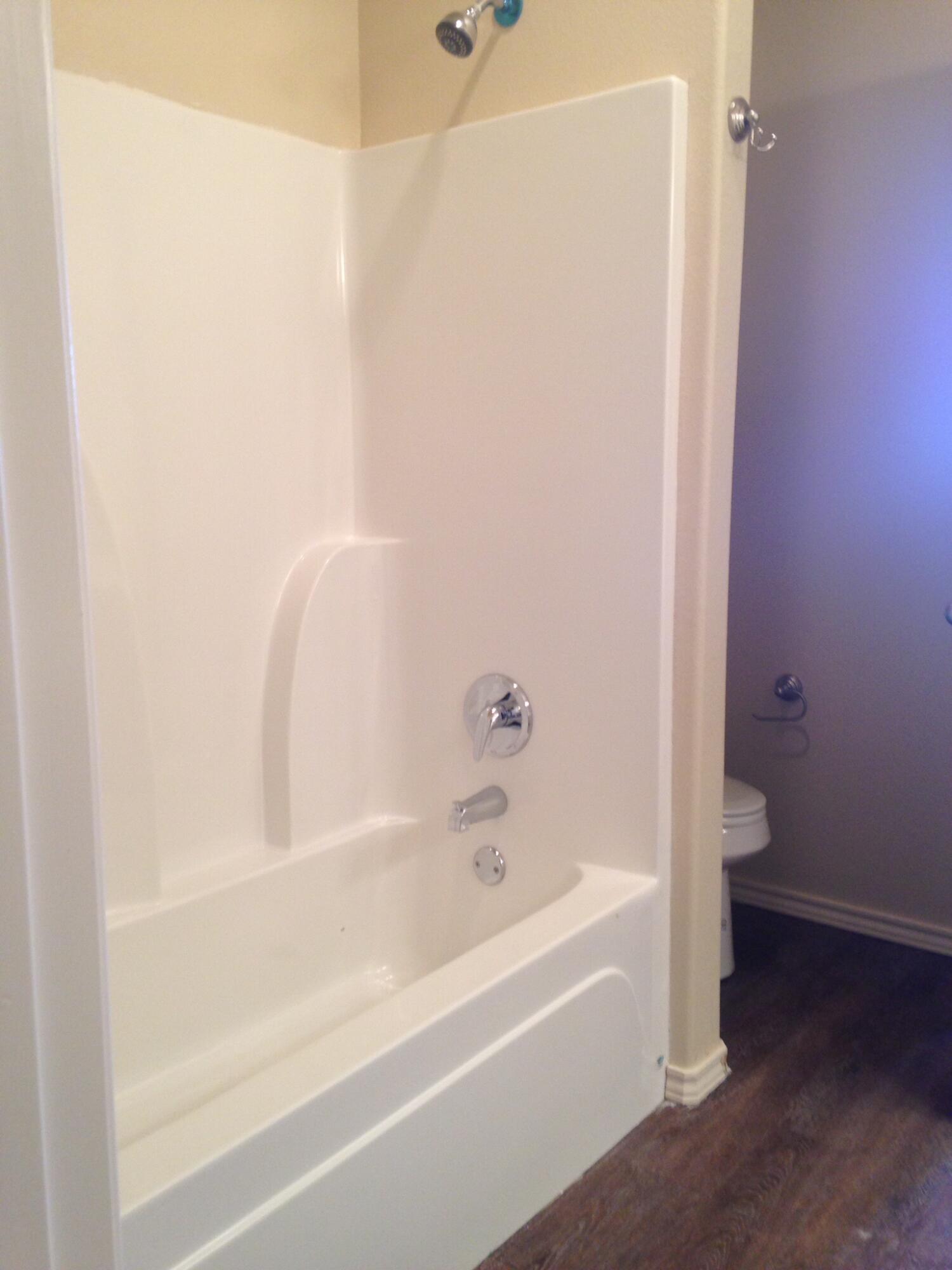 1212 Preston Trail, Unit A Wolfforth, TX 79382 - Photo 9 of 12 a bathroom with bathtub and shower