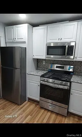a kitchen with stainless steel appliances a stove a microwave and sink