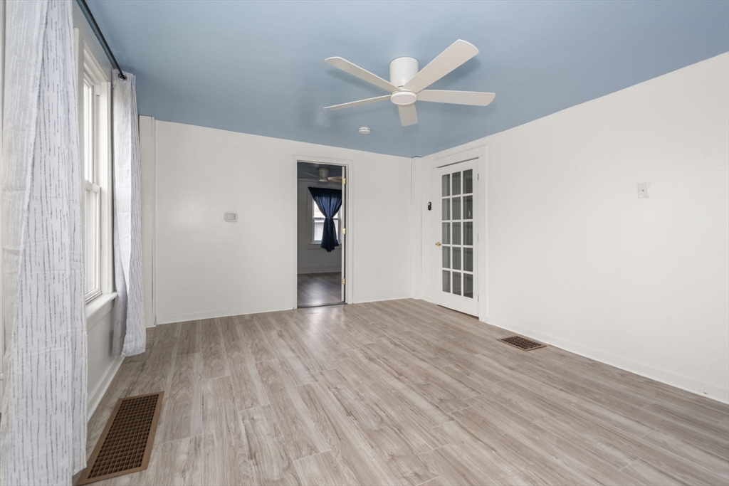 97 Mechanic Street Westfield, MA 01085 - Photo 22 of 40 an empty room with wooden floor chandelier fan and windows