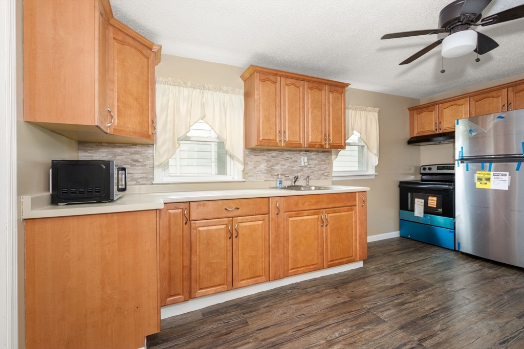 97 Mechanic Street Westfield, MA 01085 - Photo 7 of 40 a kitchen with stainless steel appliances granite countertop a stove a sink dishwasher and a refrigerator with wooden floor
