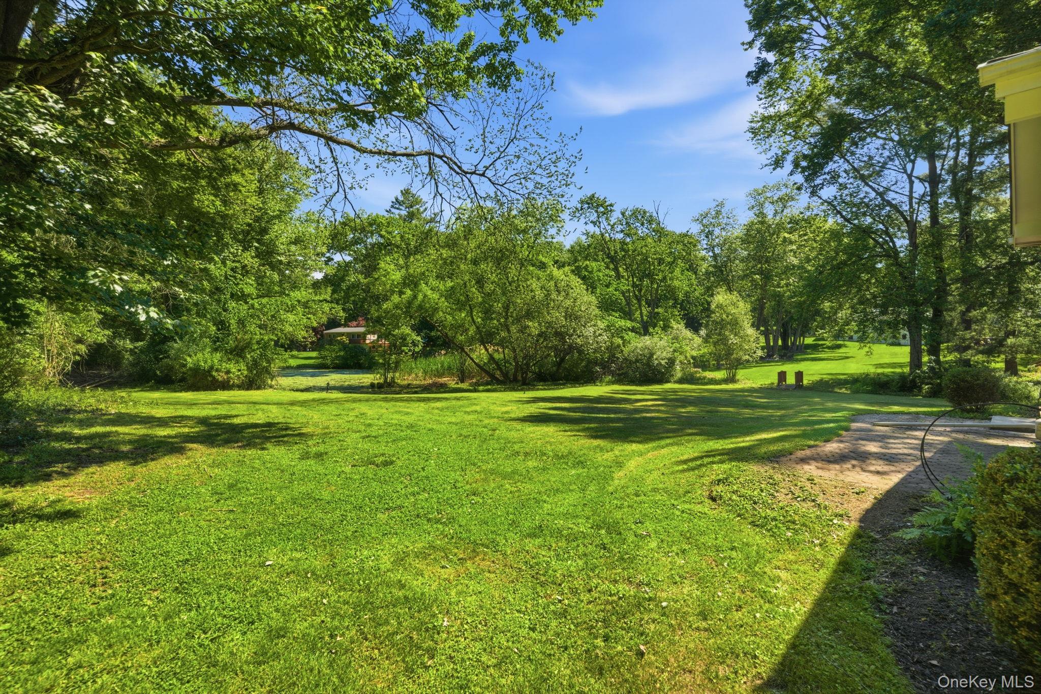 35 Deans Bridge Road Somers, NY 10589 - Photo 27 of 49 Beyond the lawn, the grounds roll back into a natural, wooded edge where a private pond sits quietly at the rear of the property, drawing in birds and wildlife all season long.