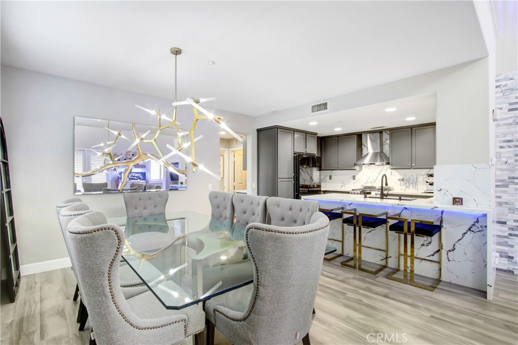 12422 Benton Drive, Unit 1 Rancho Cucamonga, CA 91739 - Photo 5 of 20 a view of a dining room with furniture a kitchen and chandelier