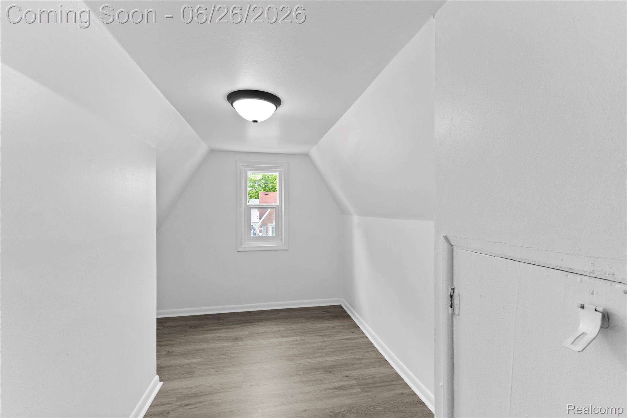 8310 Whitcomb Detroit, MI 48228 - Photo 24 of 26 Attic room featuring a single window, overhead flush-mount lighting, sloped ceilings, wood-finish flooring, and a built-in access panel
