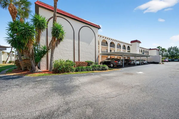 a front view of house with yard and trees in the background