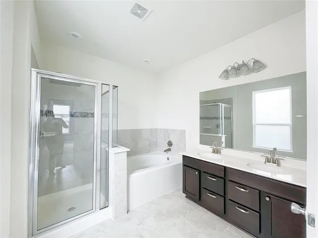 a spacious bathroom with a shower sink double vanity and tub
