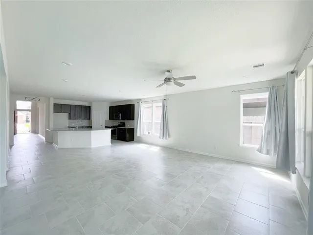 an empty room with windows and fireplace