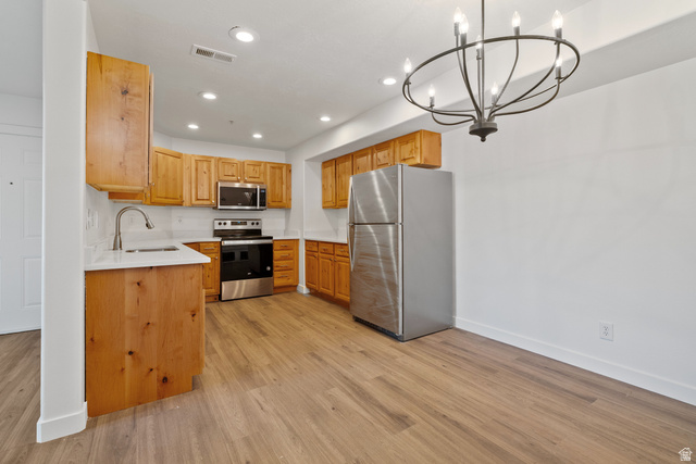 8204 North Cedar Springs Road, Unit 2 Eagle Mountain, UT 84005 - Photo 5 of 17 Kitchen with stainless steel appliances, a chandelier, and light wood-type flooring