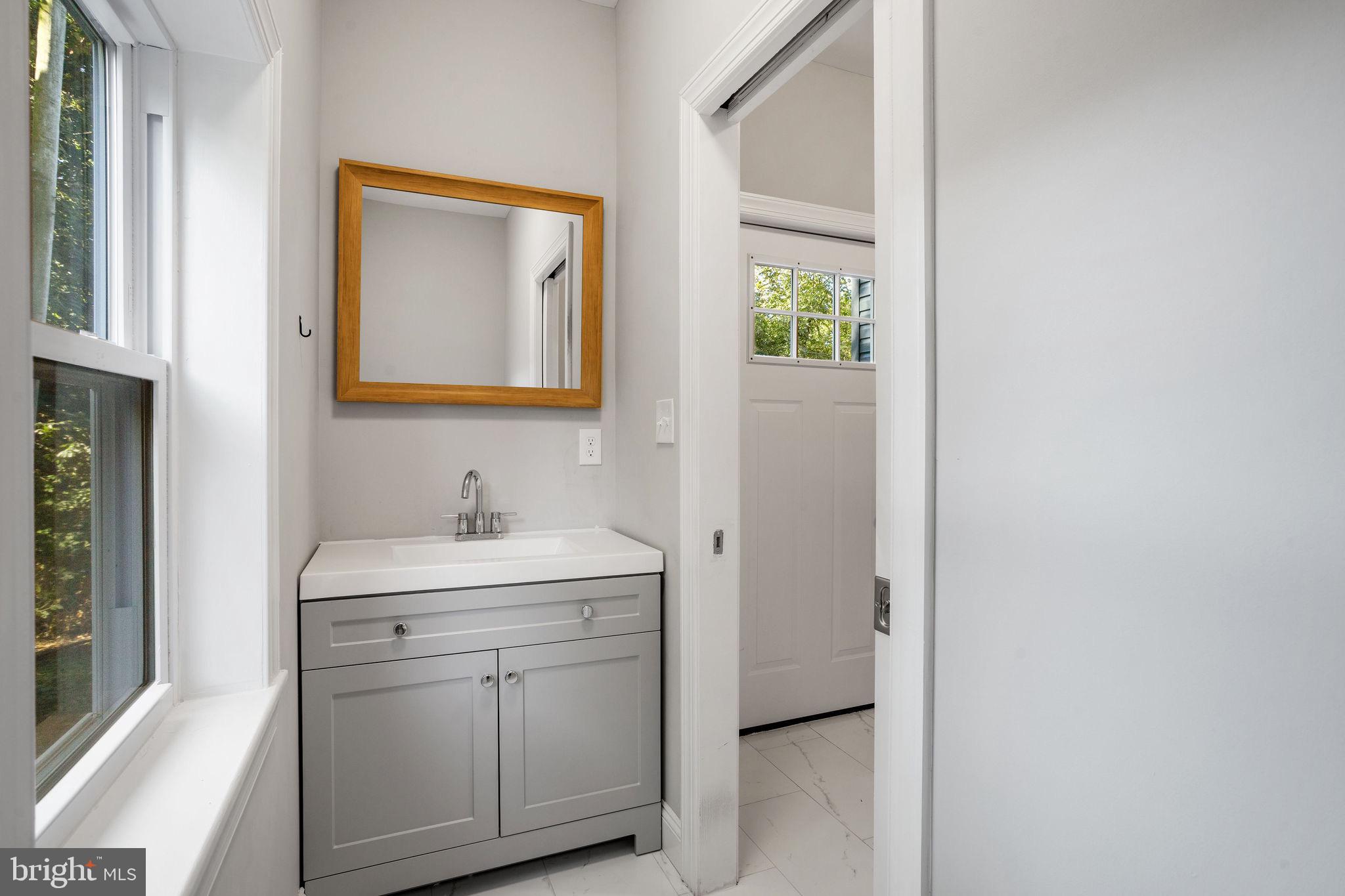 144 Snyder Place Moorestown, NJ 08057 - Photo 28 of 36 a bathroom with a toilet a sink a mirror and next to a window