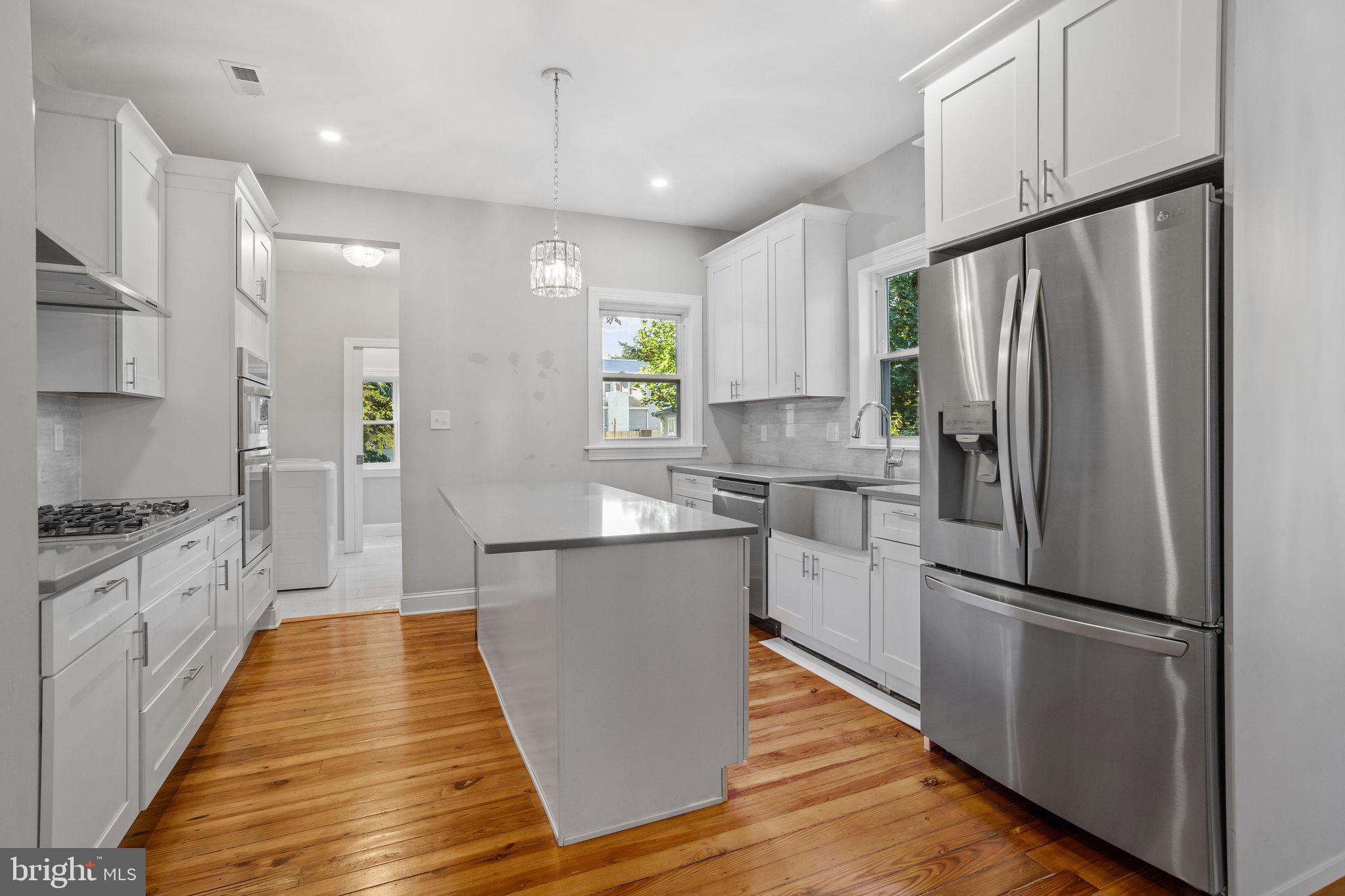 144 Snyder Place Moorestown, NJ 08057 - Photo 30 of 36 a kitchen with stainless steel appliances granite countertop a refrigerator a sink dishwasher a stove and white cabinets with wooden floor