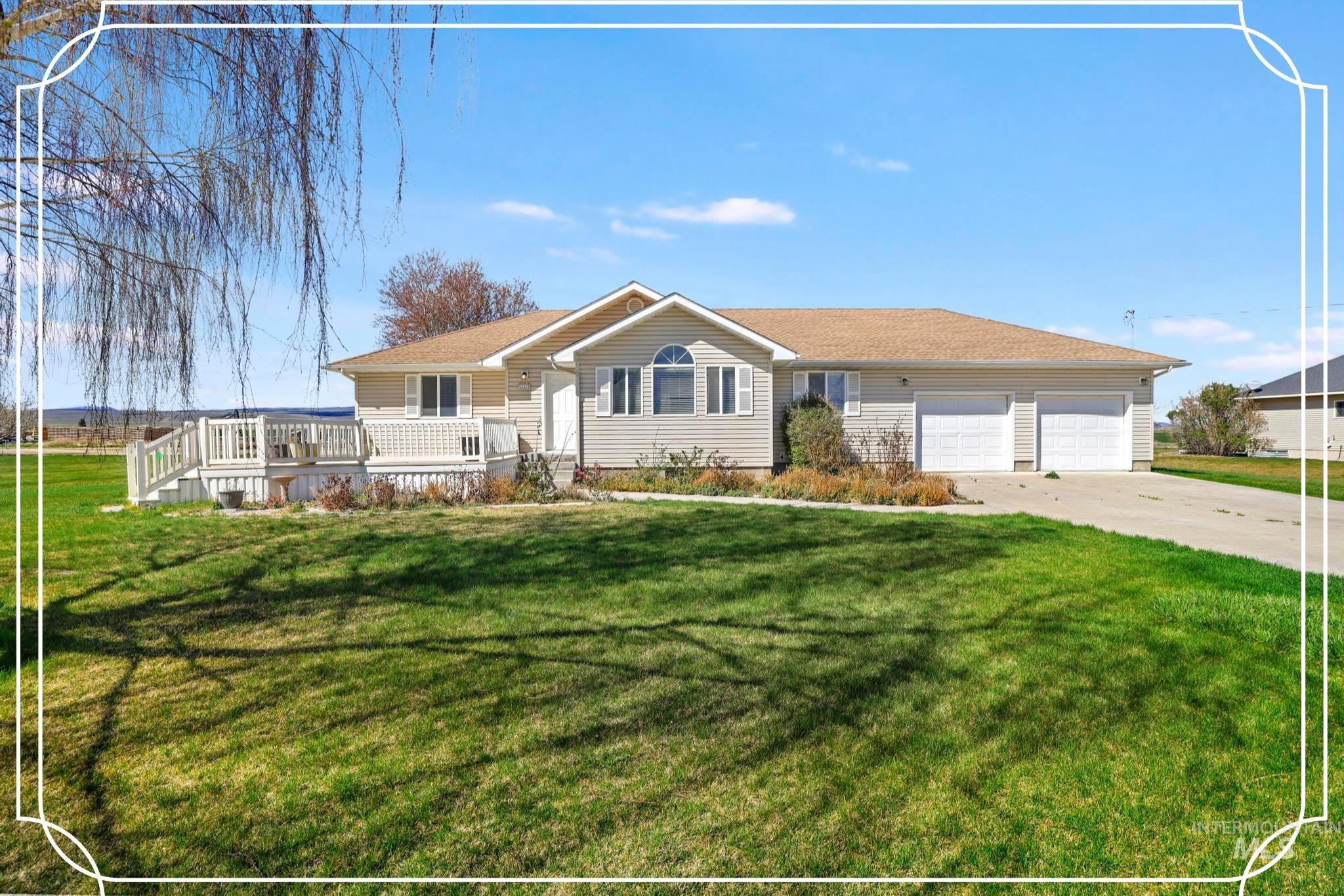 Single story home with a front lawn, driveway, a garage, and a deck