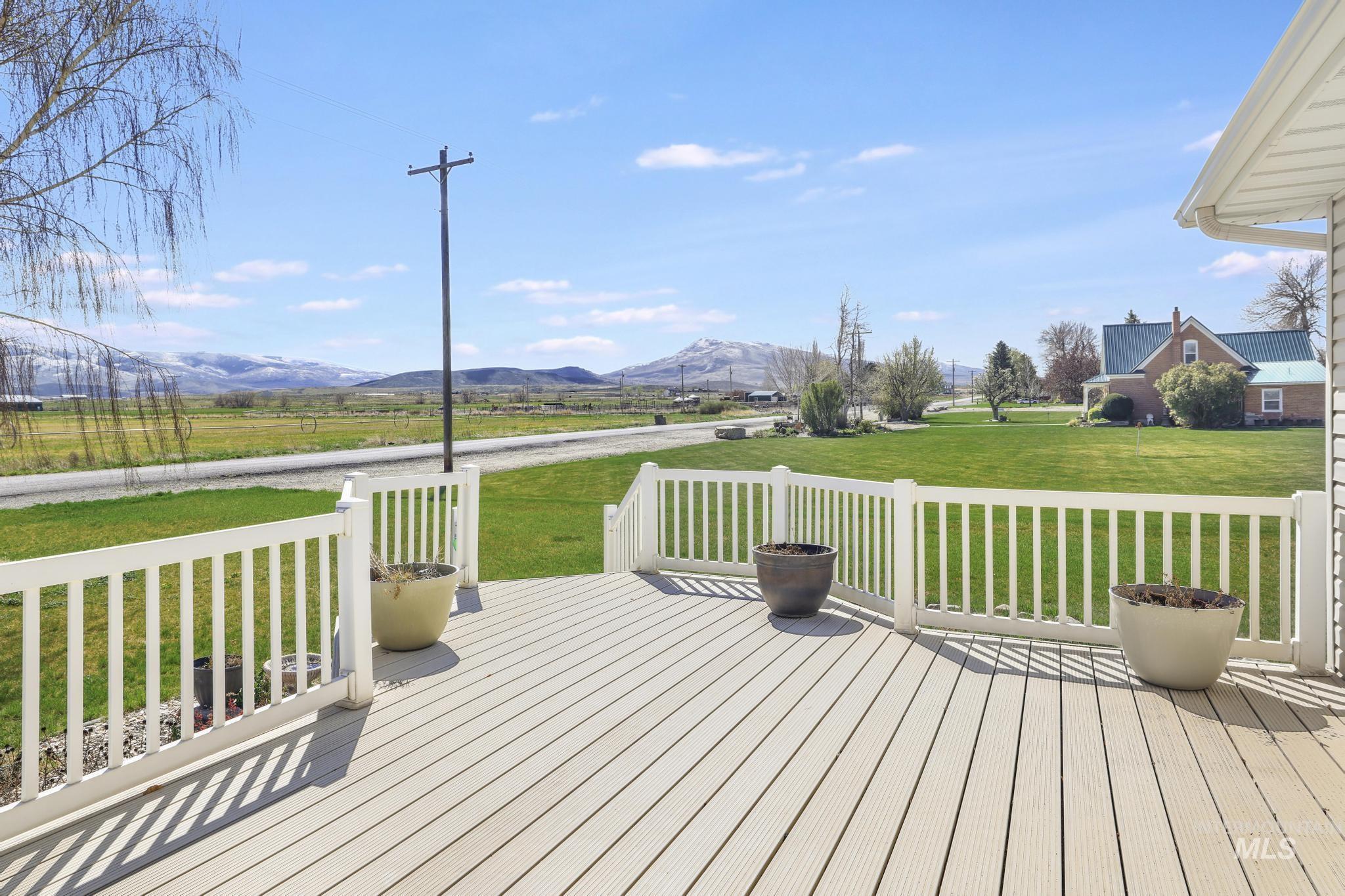445 South College Street Oakley, ID 83346 - Photo 19 of 24 Wooden terrace with a mountain view and a yard